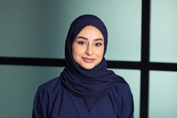 Latifa Bin Haider, an Emirati social entrepreneur, stands confidently with a backdrop of modern cityscape. She is a driving force behind innovative initiatives such as Baytuki, a crowdfunding platform for Emirati women, and Mental Health AE, a movement aimed at destigmatizing mental health issues. Her passion for empowering women and fostering social change shines through in her determined expression.