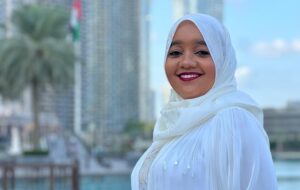 An empowering and inspirational scene featuring Chada El Islam Benmahcene. She stands confidently, exuding professionalism and dedication. In the background, there are subtle elements representing technology, energy, and entrepreneurship. The image reflects her dynamic impact on various fields and her commitment to empowerment.