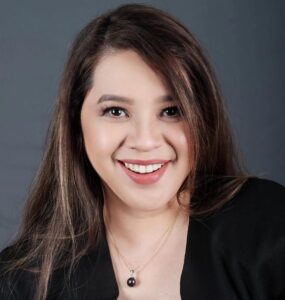 A portrait of Owen SP Sanchez, a distinguished HR professional and public figure. She exudes confidence and determination, reflecting her journey of accomplishment and empowerment. The background showcases symbols of achievement and leadership, underlining her role in breaking barriers and inspiring change.