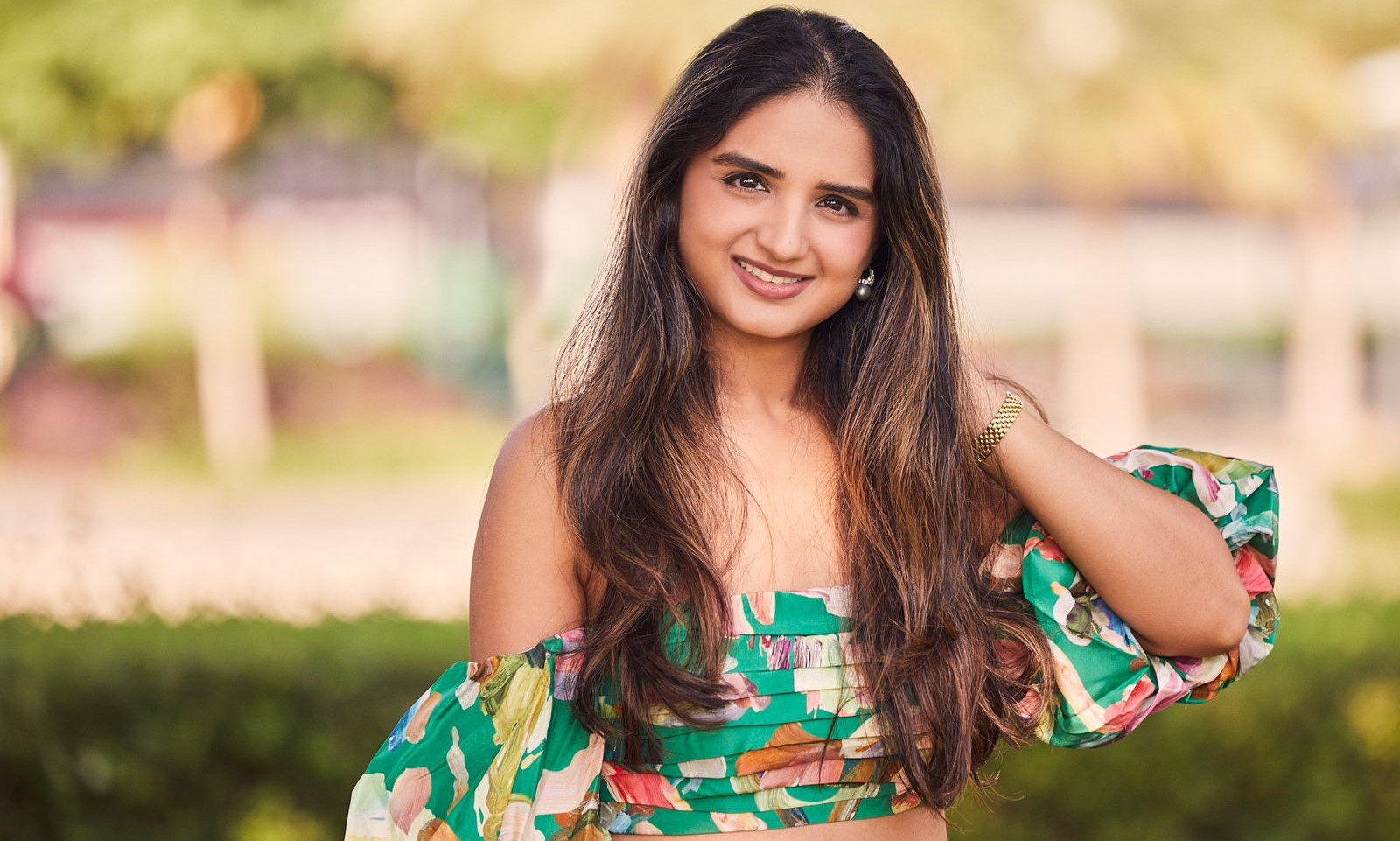 A portrait of Kanupriya Saraf, a skilled energy healer and spiritual entrepreneur, against a backdrop of Dubai's modern skyline. She exudes confidence and positivity, symbolizing her unique life journey and dedication to holistic wellness.