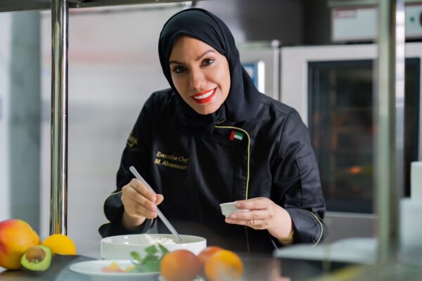 Image featuring Chef Mariam Almansoori in the kitchen of Montauk Boutique Café & Restaurant, Abu Dhabi, surrounded by fresh ingredients and culinary tools, showcasing her passion for Emirati cuisine and her dedication to creating authentic and heartfelt dishes