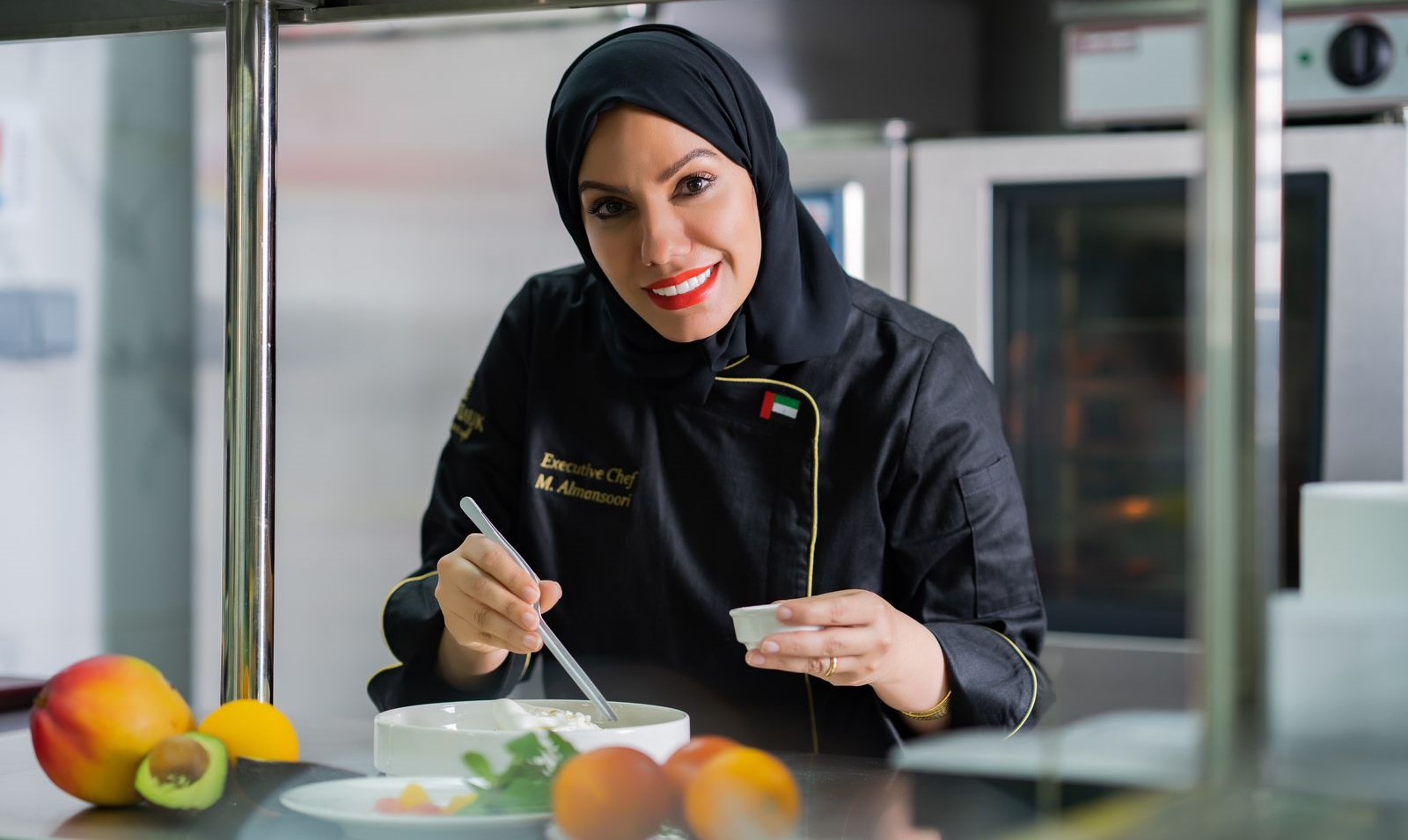 Image featuring Chef Mariam Almansoori in the kitchen of Montauk Boutique Café & Restaurant, Abu Dhabi, surrounded by fresh ingredients and culinary tools, showcasing her passion for Emirati cuisine and her dedication to creating authentic and heartfelt dishes