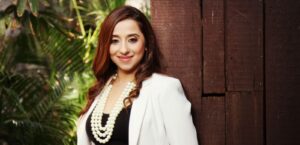 A captivating image of Shradha Salla, a renowned tarot reader and entrepreneur, radiating positivity and warmth. She exudes confidence and serenity in her beautifully appointed garden studio in Bandra West. The photo captures her deep connection with mystical arts, including tarot reading, numerology, and holistic living. Shradha's achievements and dedication to well-being shine through in this image, making her an inspiring figure for those seeking guidance and positivity.