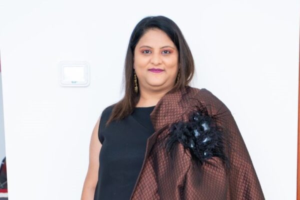 Anul Mundra, the founder of XpatzHub, exudes confidence and leadership in a vibrant and modern Dubai business setting. The image captures her as a dynamic entrepreneur and leader. Surrounding her are logos representing various media outlets and awards she has received, showcasing her influence in the business and social entrepreneurship space. The XpatzHub logo is prominently displayed, symbolizing the company's role as a hub for marketing and event solutions. The image embodies Anul Mundra's remarkable journey and the innovative approach of XpatzHub in Dubai's business and event management landscape.