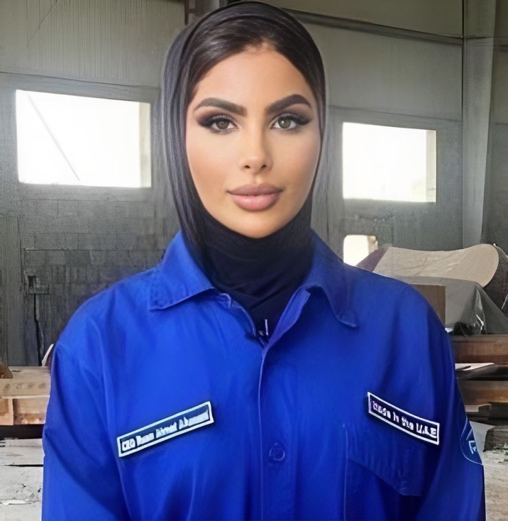 Reem Al Hassani, a pioneering Emirati entrepreneur and sports trailblazer, stands confidently with an award in hand, surrounded by a backdrop of water sports equipment and boats. She is celebrated for her groundbreaking achievements in nautical clubs, competitive rowing, and entrepreneurship