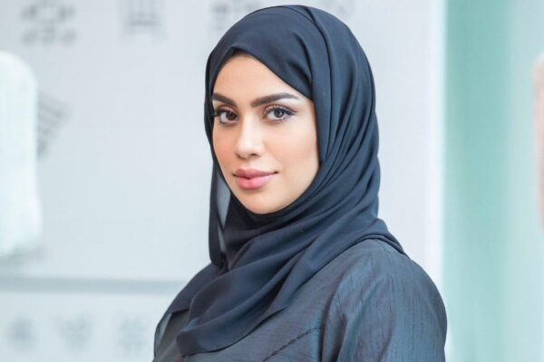 A professional portrait of Hamda Hassan Al Raeesi, a distinguished figure in finance and public service. She is dressed in formal attire and exudes confidence and professionalism.