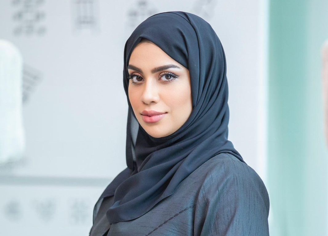 A professional portrait of Hamda Hassan Al Raeesi, a distinguished figure in finance and public service. She is dressed in formal attire and exudes confidence and professionalism.