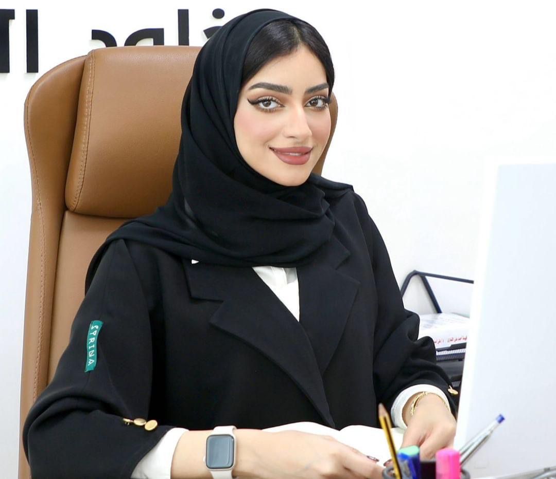 A professional portrait of Khulood Al Khudoori, a distinguished lawyer and legal consultant. She exudes confidence and determination, symbolizing her commitment to the field of law and justice. In the background, there are subtle legal motifs, emphasizing her role in the legal landscape.