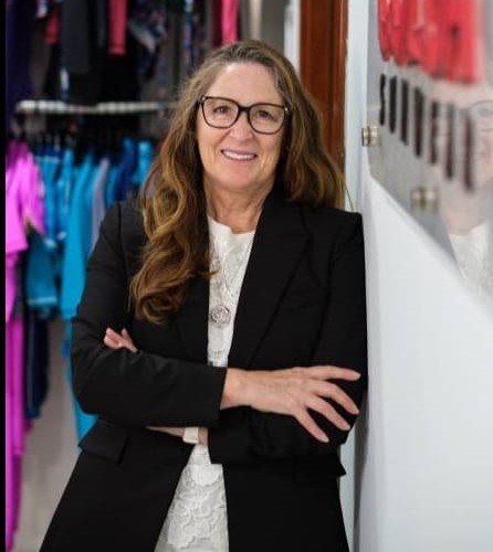 Maureen Hall, founder and CEO of COÉGA Sunwear, a top-tier swimwear brand in the UAE, reflects on her journey of determination, innovation, and commitment to inclusivity. The image showcases Maureen Hall and various COÉGA Sunwear products, embodying the brand's dedication to sustainable and inclusive swimwear, as well as its philanthropic initiatives.